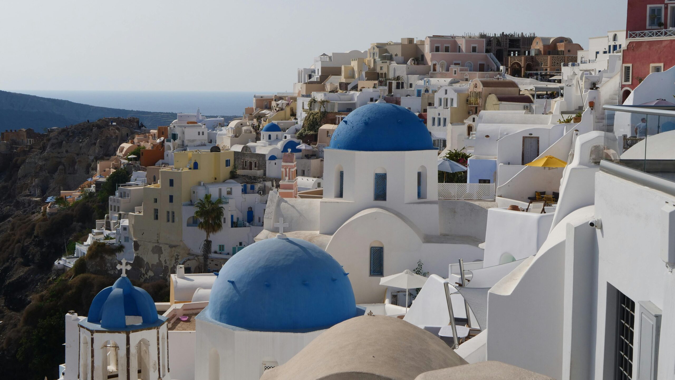 A picturesque view of Oia, Greece showcasing Santorini's iconic blue-domed churches and whitewashed buildings.
