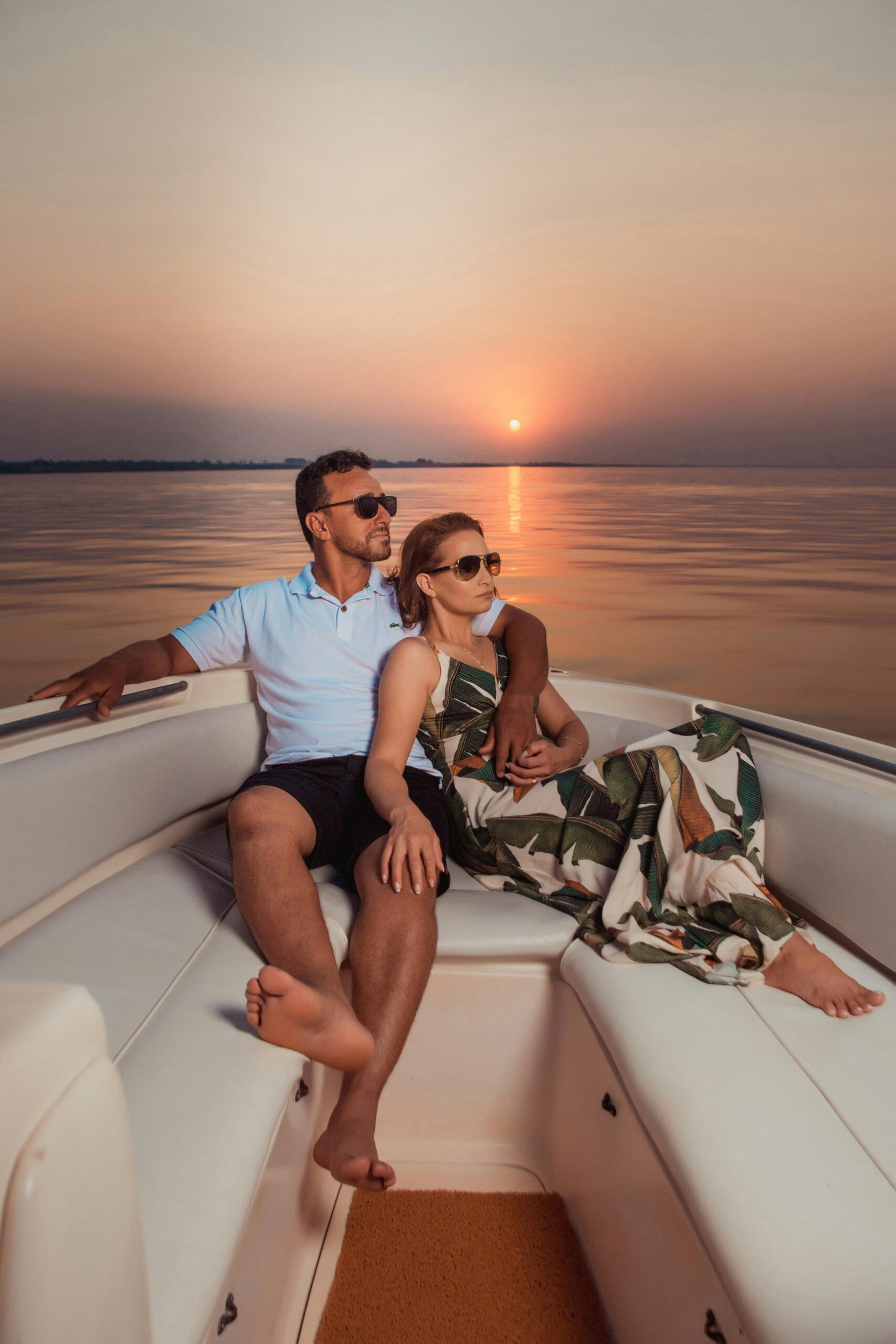 Couple enjoying a peaceful sunset together on a yacht during vacation.
